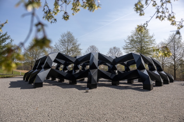 Thursday, April 9, 2026 - "smug," Tony Smith's 1973 aluminum outdoor sculpture was an unfinished work when Smith died in 1980. The Glenstone Museum of Art, in partnership with the artist's estate, supported the completion of the work in 2005. Smith's work uses geometric shapes that allow the viewer to change their perspective depending on where they are standing.