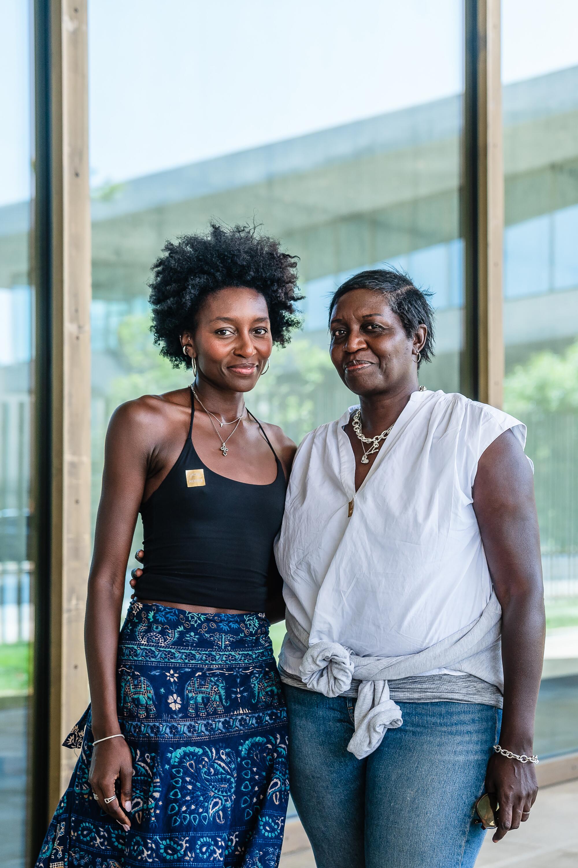 Two women stand in front of a glass wall on the first floor of the museum.