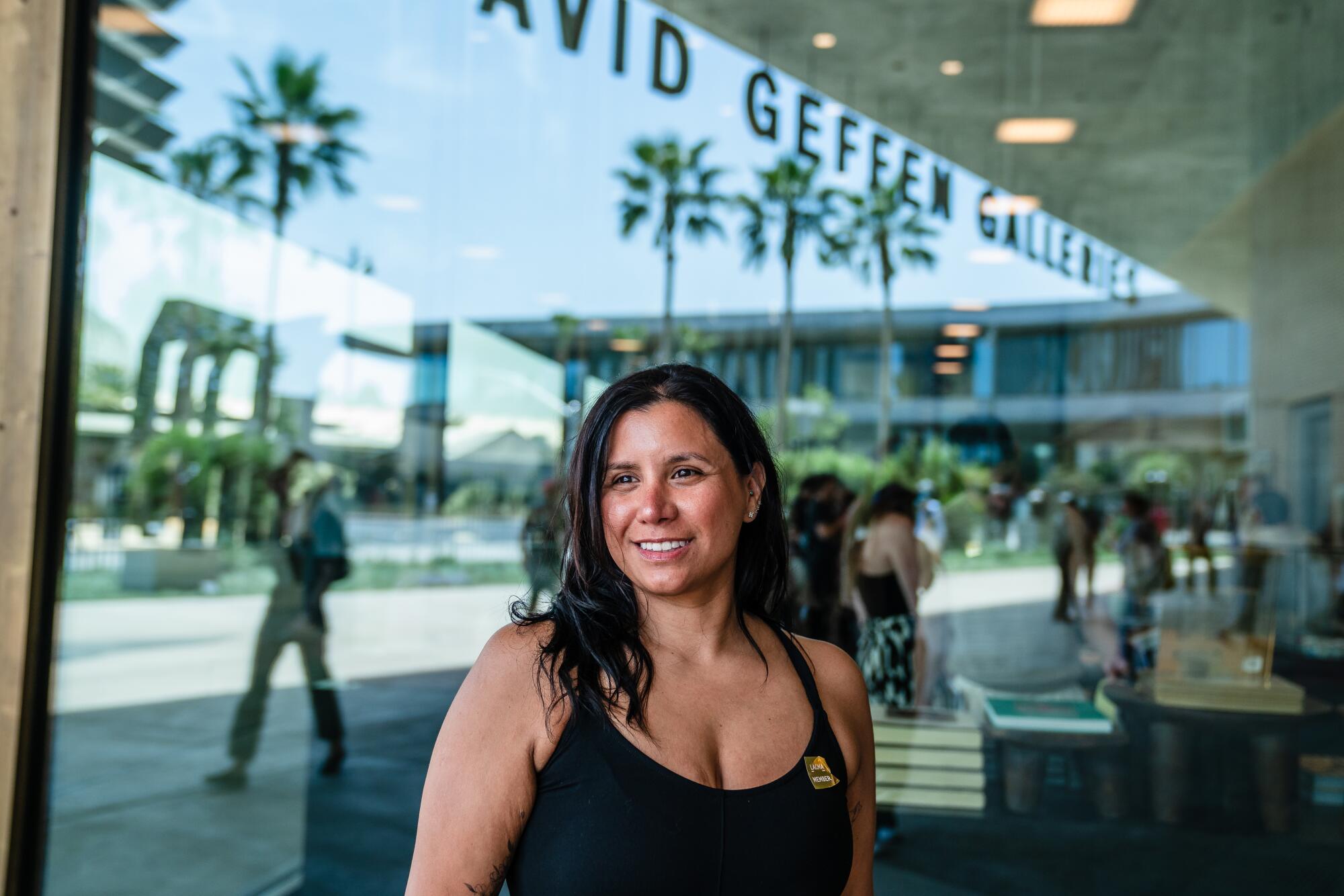 A woman is standing in front of a cafe window.
